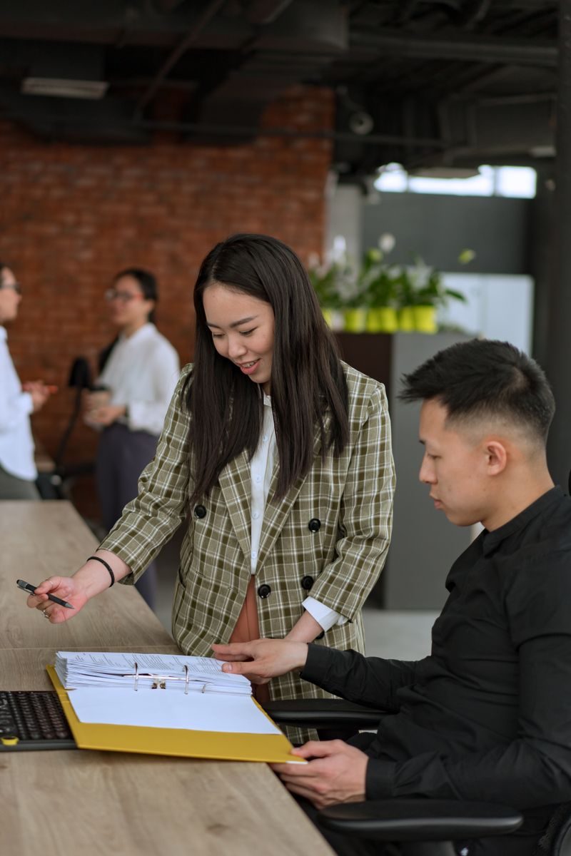 Two professionals collaborate on a project at a modern office shared workspace.